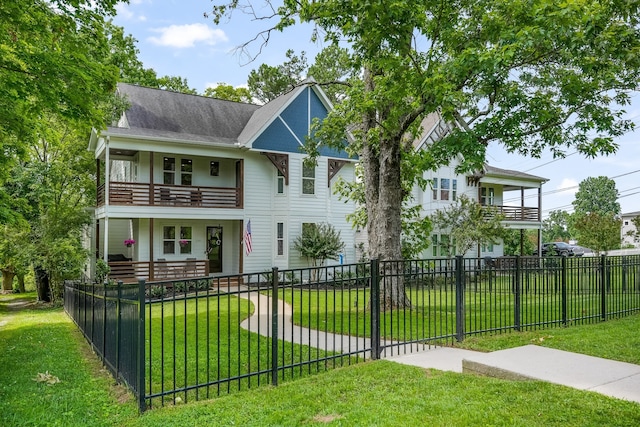 view of front facade with a balcony and a front yard