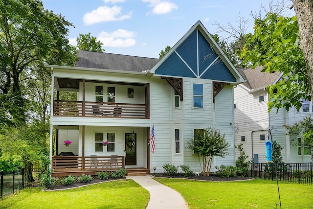 view of front facade featuring covered porch, a balcony, and a front lawn