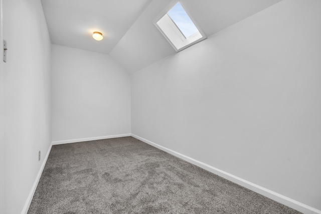 bonus room with carpet and vaulted ceiling with skylight