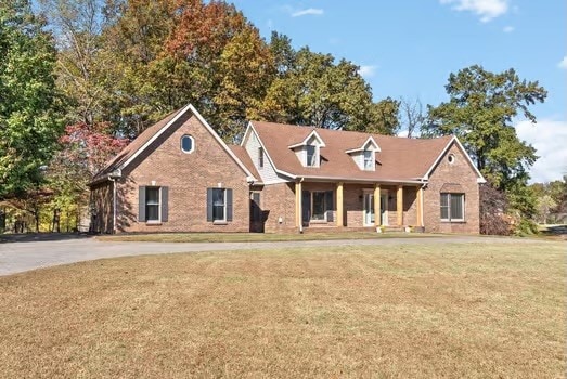 cape cod home featuring a front lawn