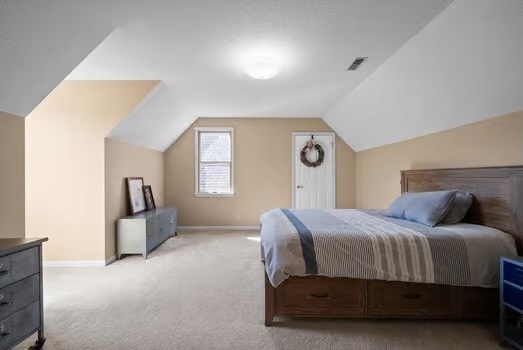 carpeted bedroom with vaulted ceiling