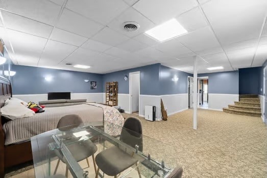 interior space with a paneled ceiling and carpet flooring