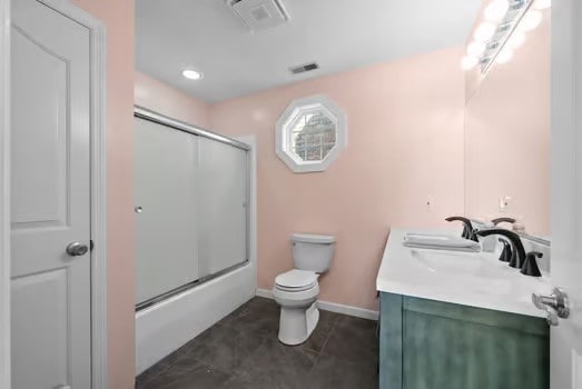 full bathroom with vanity, combined bath / shower with glass door, toilet, and tile patterned floors