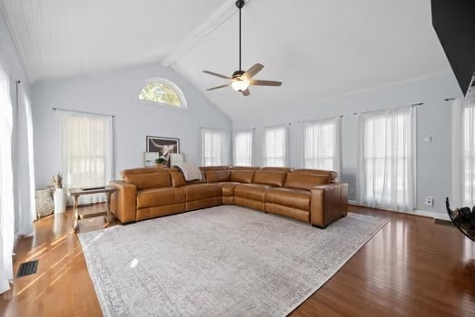 living room with beam ceiling, hardwood / wood-style floors, high vaulted ceiling, and ceiling fan