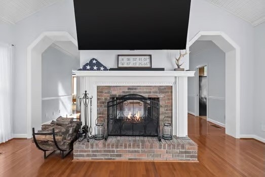 details featuring hardwood / wood-style floors and a brick fireplace