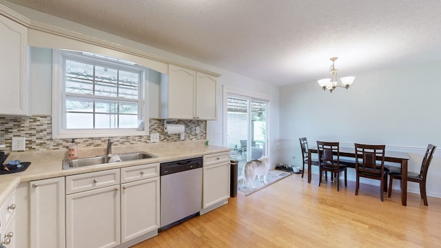 kitchen with dishwasher, sink, pendant lighting, light wood-type flooring, and white cabinetry