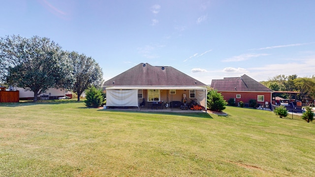 rear view of property with a yard and a patio area