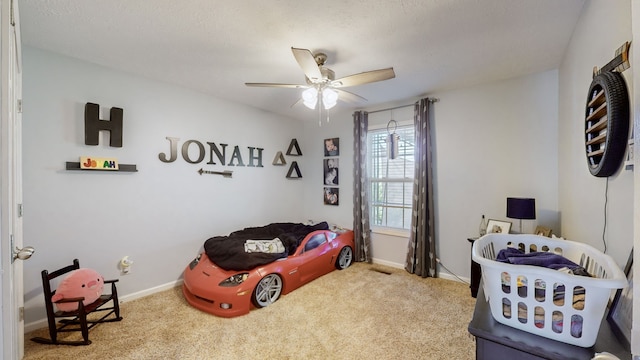 bedroom with a textured ceiling, carpet flooring, and ceiling fan