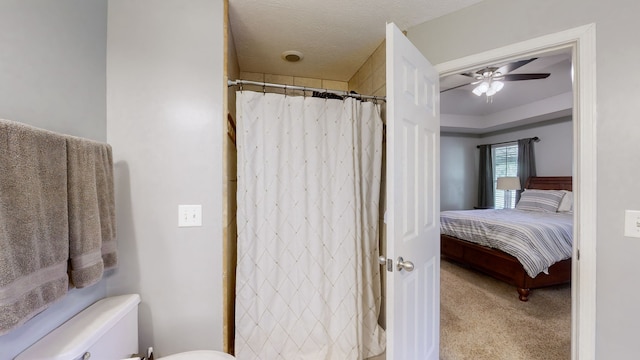 bathroom featuring a shower with shower curtain, a textured ceiling, toilet, and ceiling fan