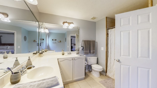 bathroom with vanity, toilet, and tile patterned floors