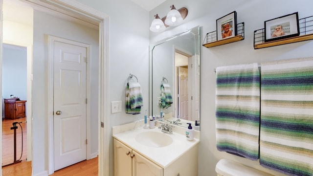 bathroom with vanity, toilet, and wood-type flooring