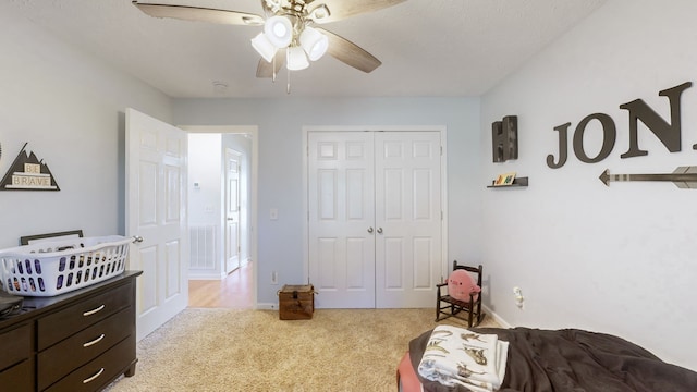 carpeted bedroom featuring a closet, ceiling fan, and a textured ceiling