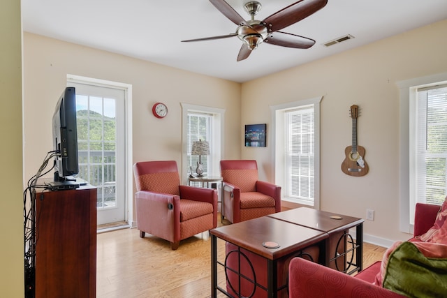 living room with light hardwood / wood-style floors, a wealth of natural light, and ceiling fan