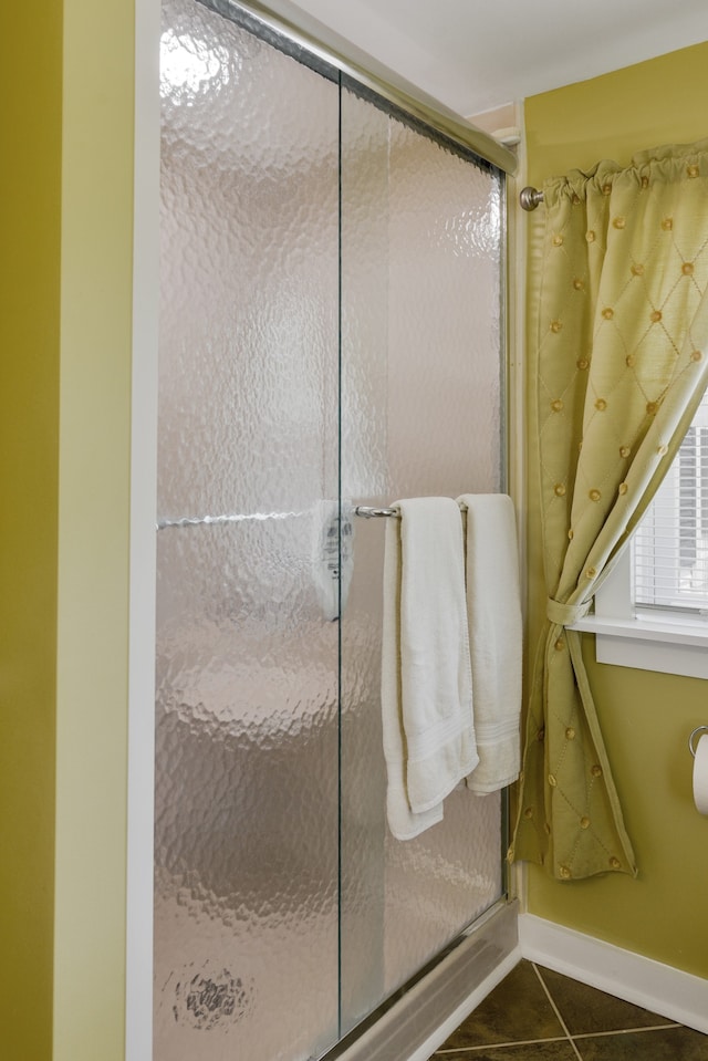 bathroom with a shower with shower door and tile patterned flooring