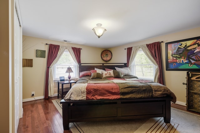 bedroom featuring dark wood-type flooring and multiple windows