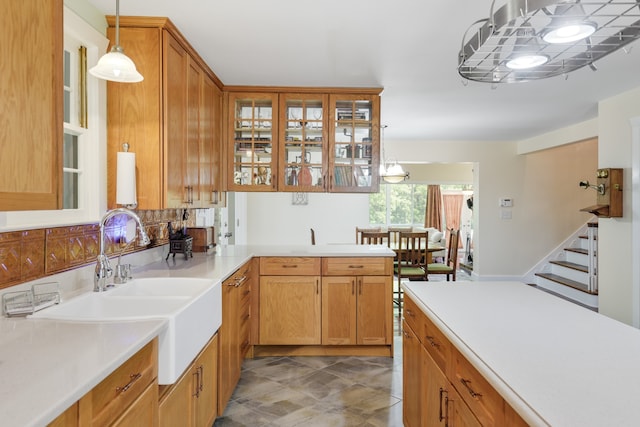 kitchen with sink, backsplash, decorative light fixtures, and kitchen peninsula