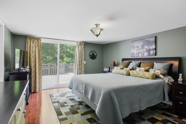 bedroom with access to outside and wood-type flooring