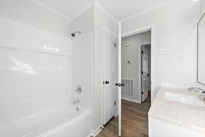 bathroom featuring vanity, bathing tub / shower combination, and hardwood / wood-style flooring