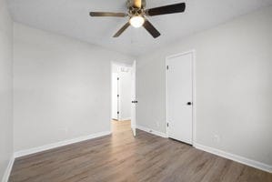 spare room featuring ceiling fan and dark hardwood / wood-style flooring