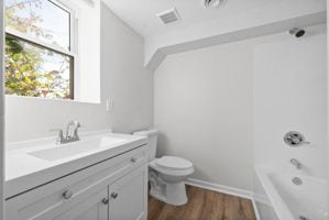 full bathroom with toilet, hardwood / wood-style floors, vanity, and  shower combination