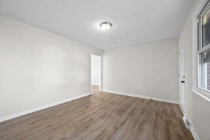 empty room with dark wood-type flooring