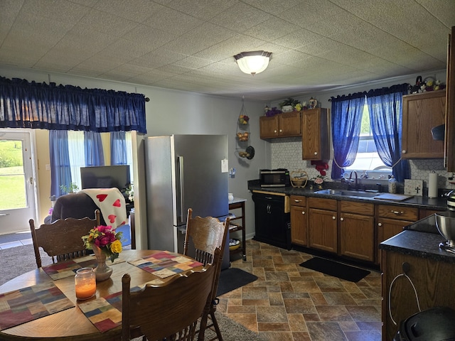 kitchen with sink, backsplash, and stainless steel refrigerator