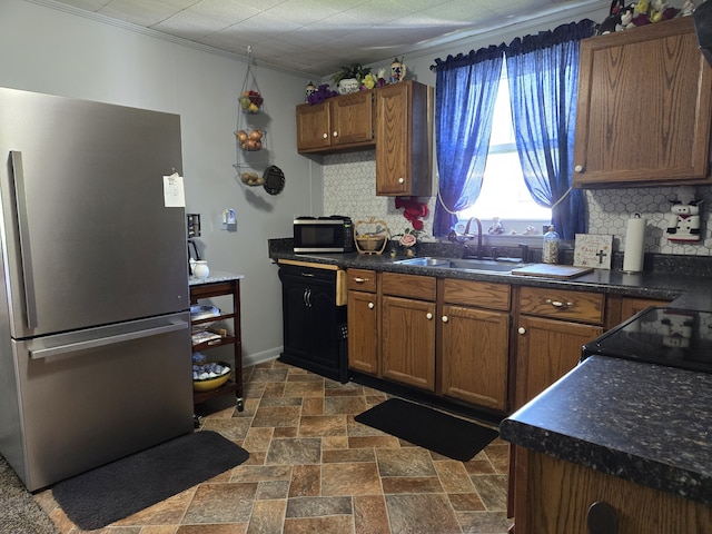 kitchen featuring ornamental molding, decorative backsplash, stainless steel appliances, and sink