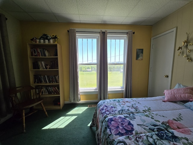 carpeted bedroom featuring a paneled ceiling and multiple windows