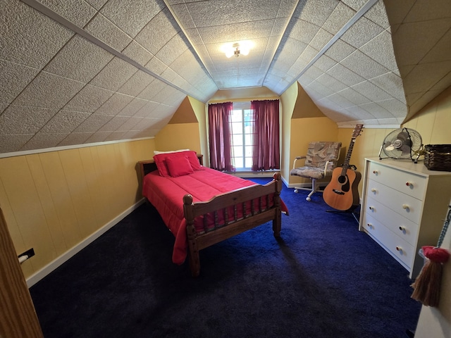 carpeted bedroom featuring wooden walls and vaulted ceiling