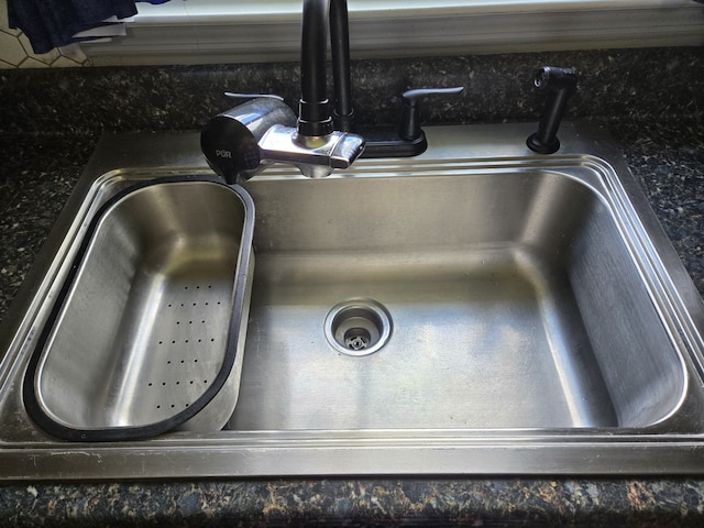 room details with dark stone countertops and sink