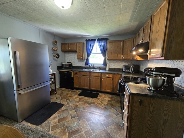 kitchen featuring decorative backsplash, sink, and stainless steel refrigerator