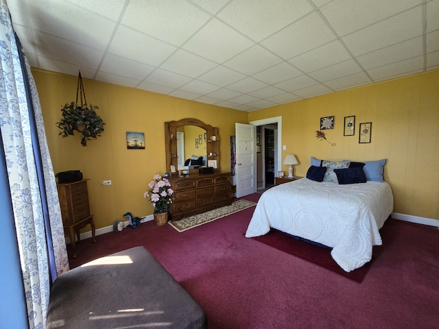 bedroom with carpet flooring and a drop ceiling