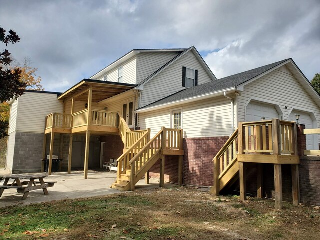 back of property featuring a wooden deck and a patio area