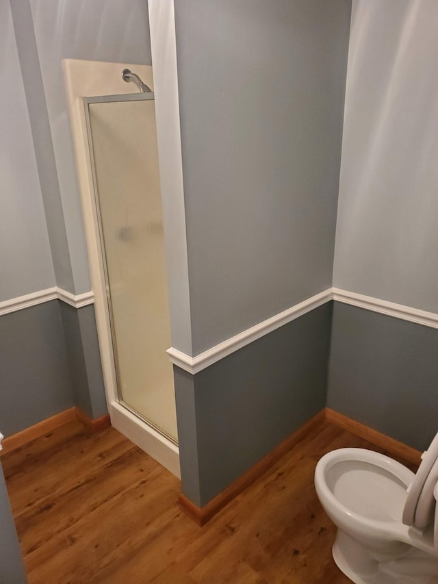 bathroom featuring toilet, walk in shower, and hardwood / wood-style floors