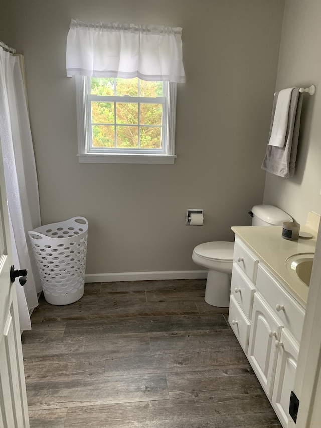 bathroom with vanity, toilet, and wood-type flooring