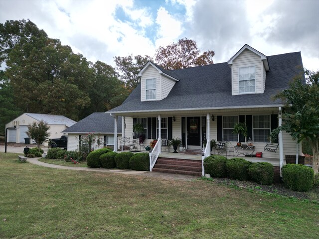 cape cod house with a front yard and covered porch