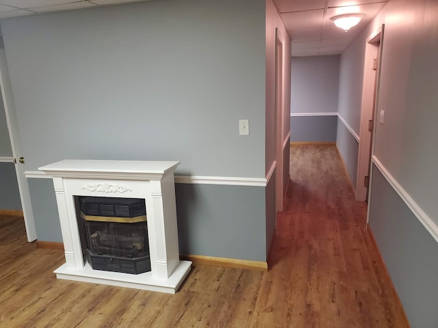 hallway featuring light hardwood / wood-style flooring and a drop ceiling