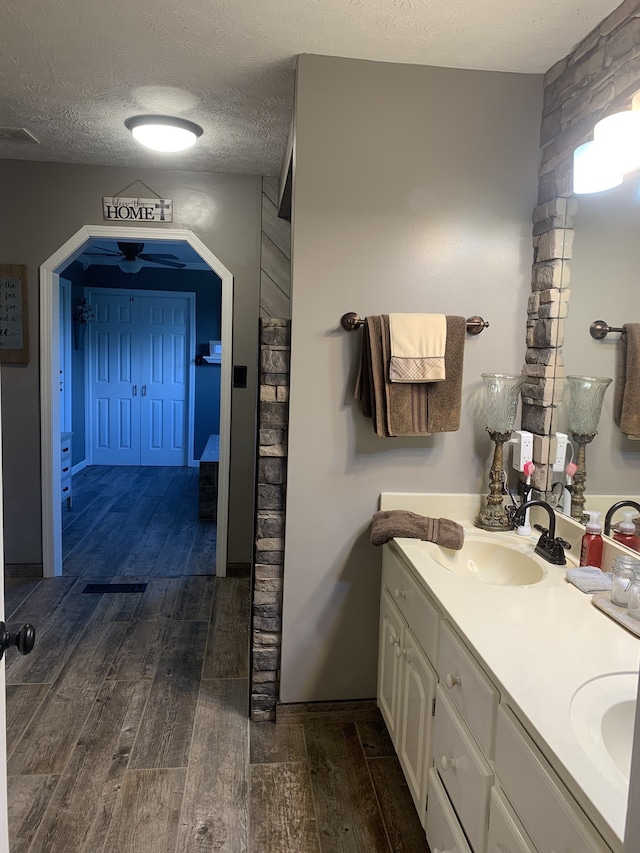 bathroom with vanity, a textured ceiling, and hardwood / wood-style flooring