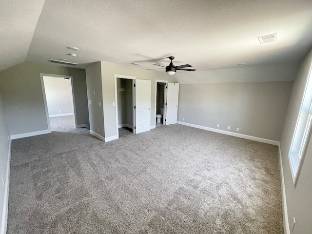 interior space with ceiling fan, a textured ceiling, carpet, and lofted ceiling