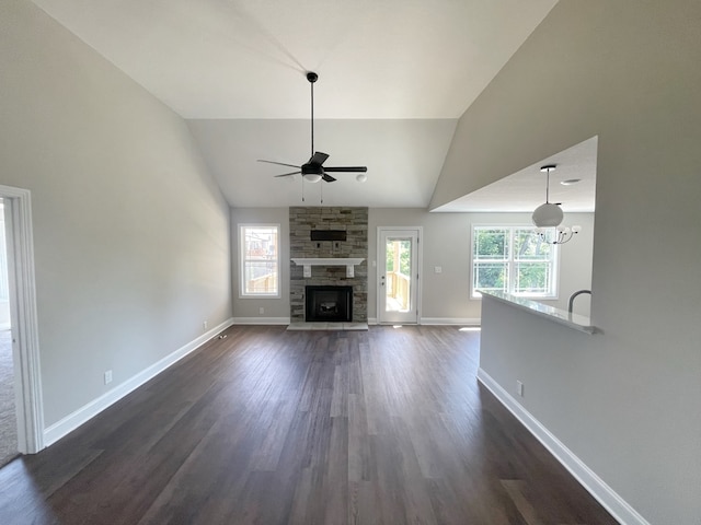 unfurnished living room with vaulted ceiling, dark hardwood / wood-style flooring, a fireplace, and ceiling fan