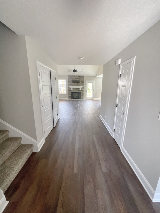 hall with a textured ceiling and dark hardwood / wood-style flooring