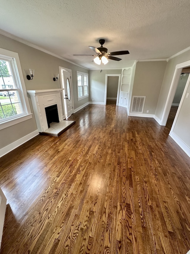 unfurnished living room featuring a textured ceiling, plenty of natural light, ceiling fan, and ornamental molding