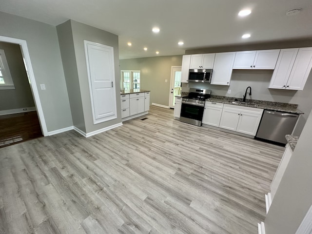 kitchen featuring sink, white cabinets, stainless steel appliances, and light wood-type flooring