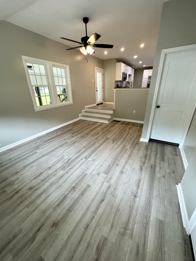 unfurnished living room featuring ceiling fan and light hardwood / wood-style flooring