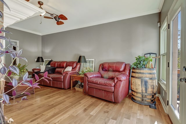 living room with light hardwood / wood-style floors, ornamental molding, and plenty of natural light