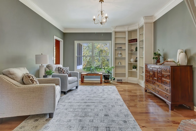 sitting room with ornamental molding, a chandelier, and light wood-type flooring