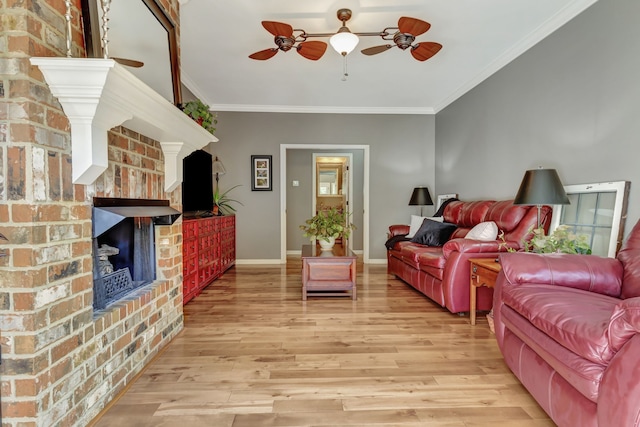 living room featuring light hardwood / wood-style floors, ornamental molding, a fireplace, and ceiling fan