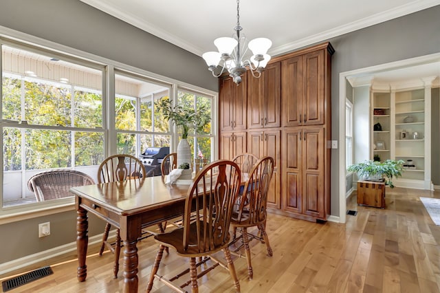 dining room featuring light hardwood / wood-style flooring, a chandelier, and crown molding