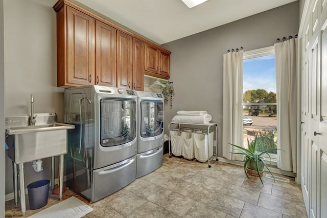 washroom featuring cabinets and washer and clothes dryer