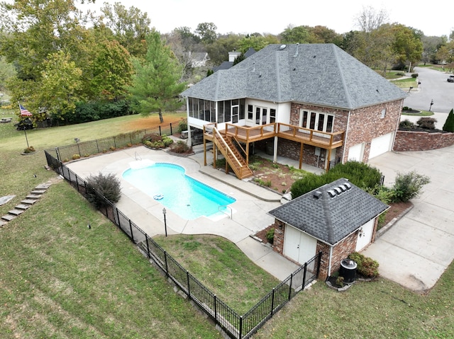 view of swimming pool featuring a yard, a patio area, and a sunroom